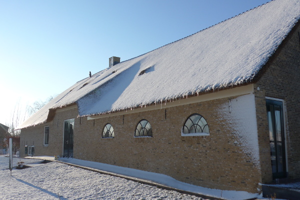 Zijaanzicht van boerderij in winterslandschap